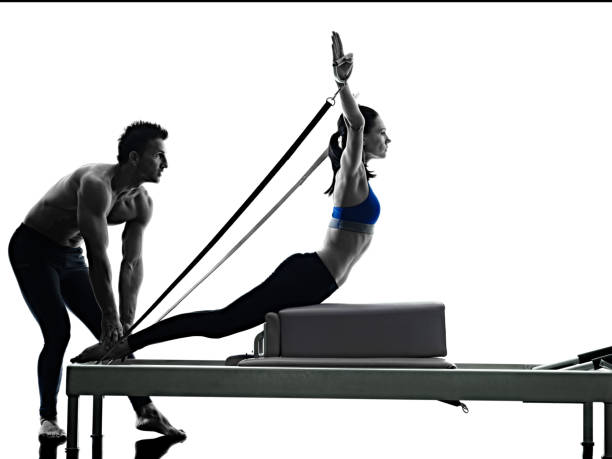 coppia pilates esercizi di fitness isolato per i diritti civili - pilates machine foto e immagini stock