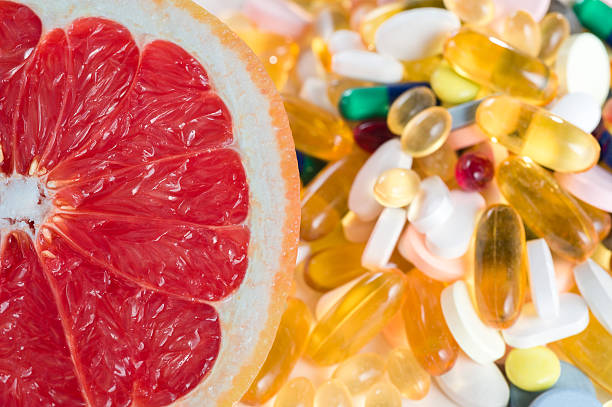 istock Pink grapefruit and pills, vitamin supplements, healthy diet concept 505411854