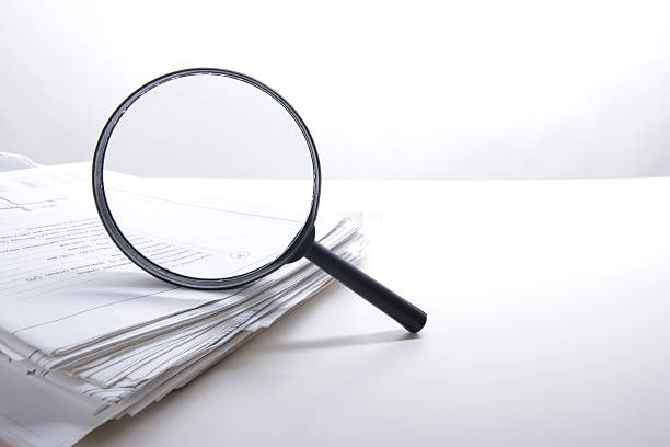 istock Architectural blueprints and blueprint rolls with magnifying glass 505412730