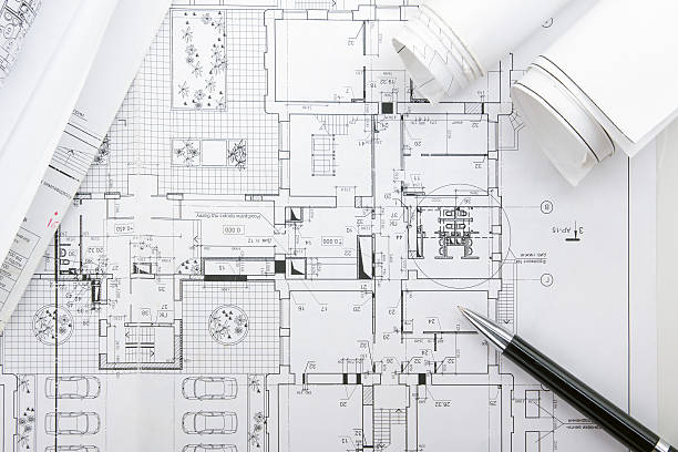istock Architectural blueprints and blueprint rolls with magnifying glass 505413092