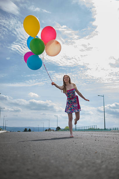 istock Young smiling woman with multi-colored balloons on a bridge. 505413462