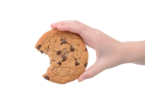 child holding a chocolate chip cookie isolated white background