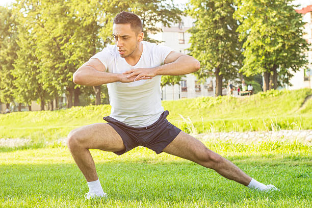 фитнес человек, осуществляющему за пределами в траве - sports training sit ups moving up sitting стоковые фото и изображения