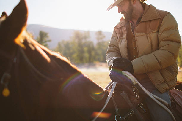 istock Close-up  of man looking down while sitting on horse 505443275