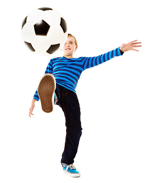 istock Energetic schoolboy kicking football. Isolated on white. 505445021