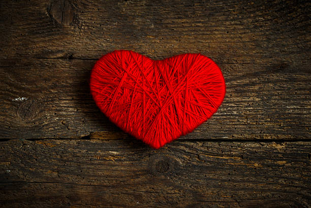 istock Red heart shape made from wool on wooden background 505465780