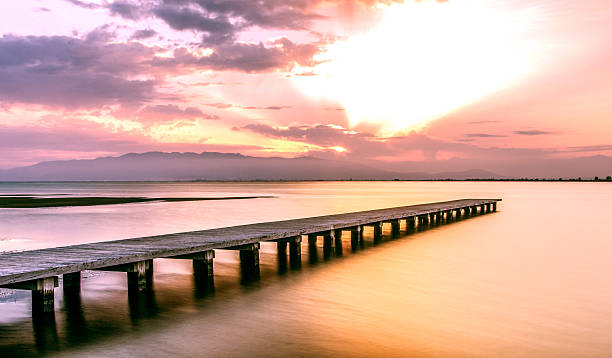 embarcadero sobre el mar delta del ebro al atardecer larga exposición - cloud morning delta landscape fotografías e imágenes de stock