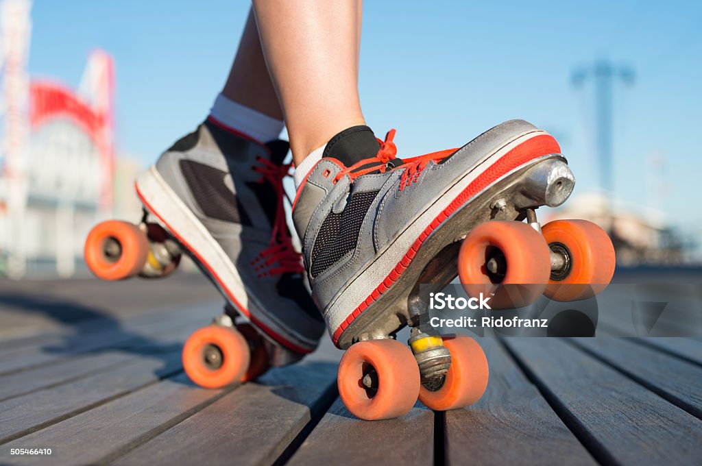 Roller skating outdoor Close up a young woman wearing rollerskates and balancing her legs on toe and heel. Close up of roller skates. Close up of a young woman in roller blade posing outdoor. Inline Skate Stock Photo