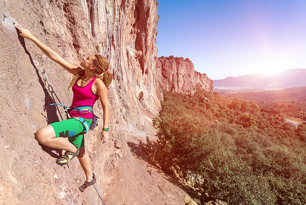 istock Hippie Style Female Climber ascending Vertical Orange Rock 505468810