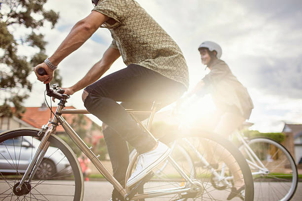 australian pareja de mediana edad montar bicicletas de regreso a casa - city bike fotografías e imágenes de stock