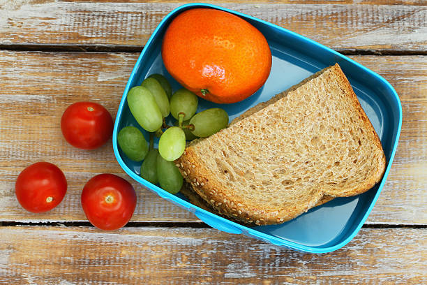 istock Healthy school lunch box containing brown sandwich, cherry tomatoes, fruit 505475784