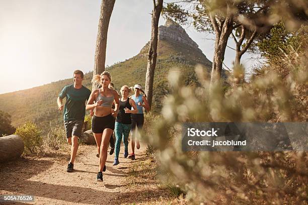 Group Of Fit People Trail Running On A Mountain Path Stock Photo - Download Image Now