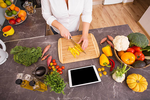 istock Woman preparing vegetarian lunch from recipe on tablet 505476550