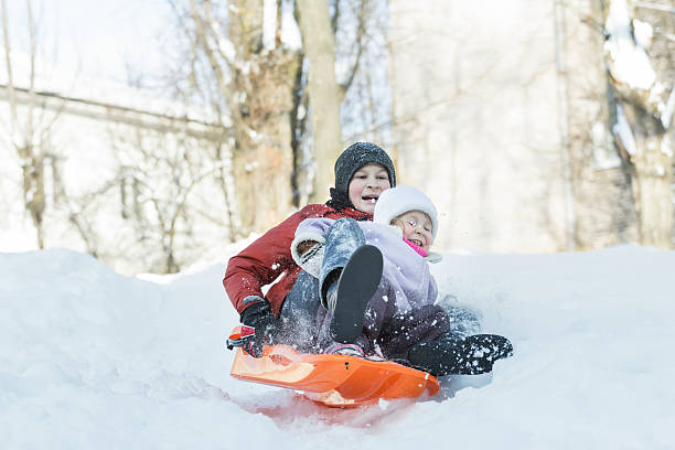 istock Siblings having downhill fun on winter plastic snow slider outdoors 505477108