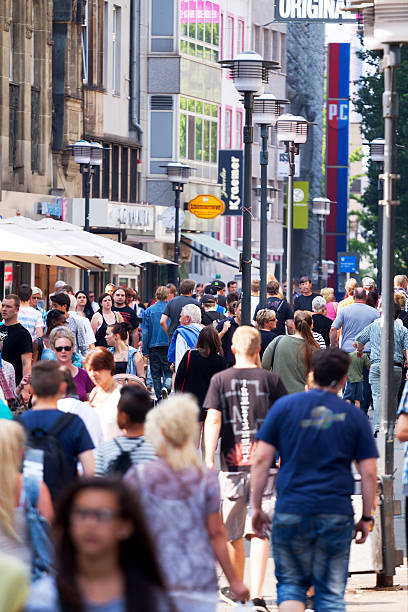 Shopping people in Essen View alomg shopping street Kettwiger Straße in summer. Many people are walking along street and stores. Non editorial shot of crowds and multiple banners and logos, none or nobody in foreground focus. essen germany stock pictures, royalty-free photos & images