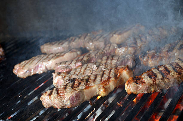 istock beef steak cooking on an open flame grill 505484631