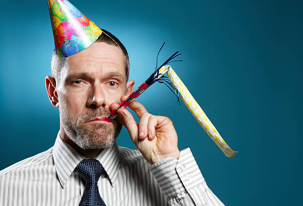 istock Man Wearing Tie With Party Hat And Horn Blower 505484847