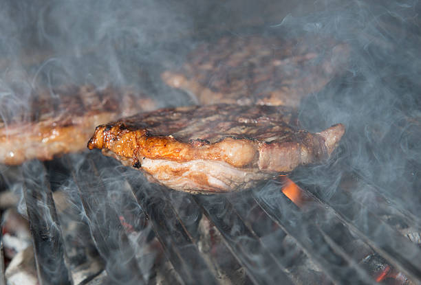 istock beef steak cooking on an open flame grill 505485707