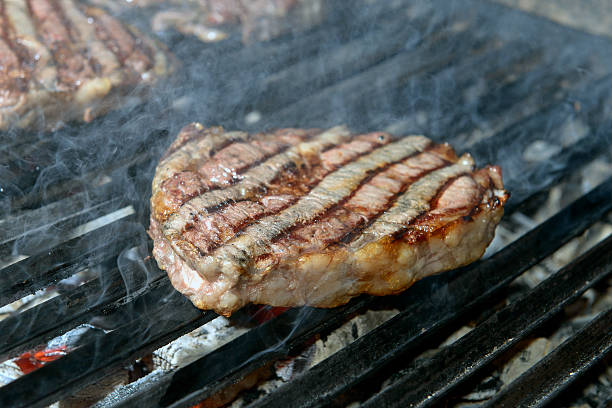 istock beef steak cooking on an open flame grill 505485877