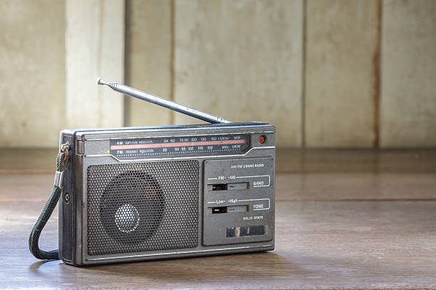Old transistor radio on wooden background.