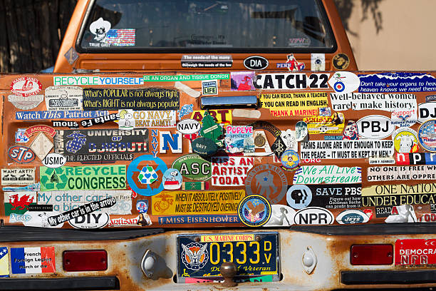 Bumper Stickers Galore: Back of Veteran's Rusty Pickup Truck Santa Fe, USA - July 17, 2014: The back of a military veteran's rusty pickup truck, covered in bumper stickers. indigo truck stock pictures, royalty-free photos & images