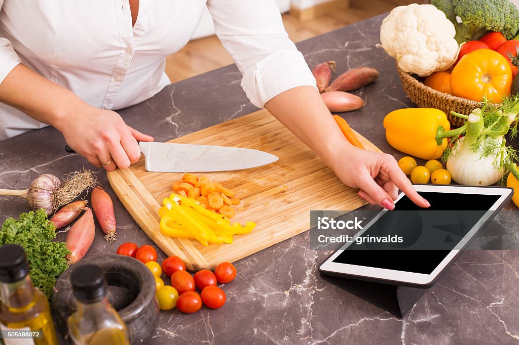 Woman following the recipe in tablet Cooking Stock Photo