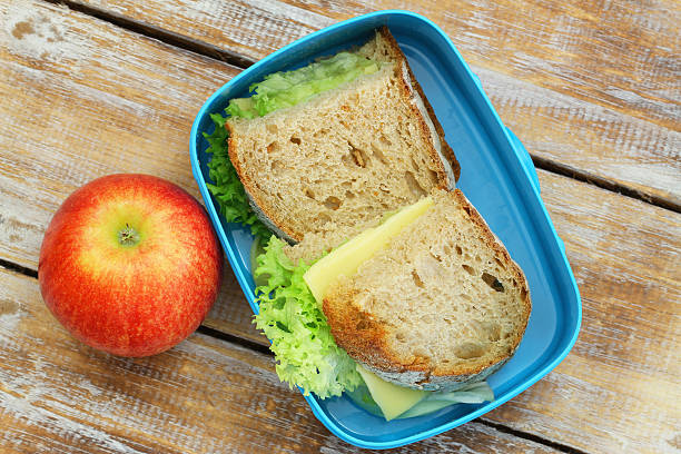 istock Healthy lunch box containing cheese sandwiches with lettuce, and apple 505488222