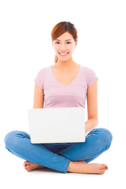 istock Smiling young woman sitting and using a laptop 505488731