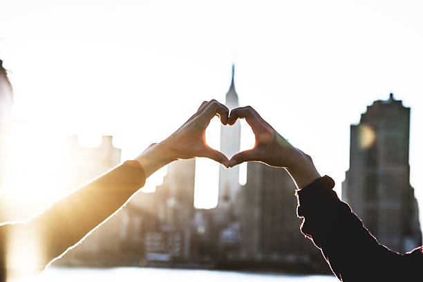 сердце формы в сумерках в нью-йорке - couple loving urban scene selective focus стоковые фото и изображения