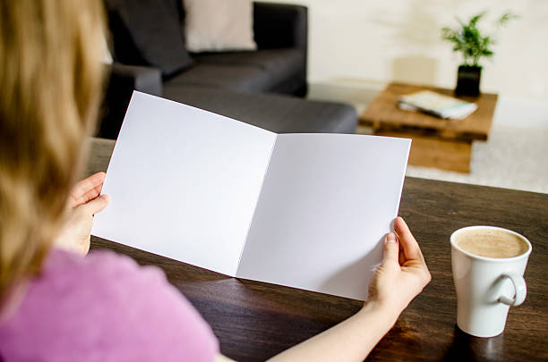 istock Woman looking at a blank brochure 505490936