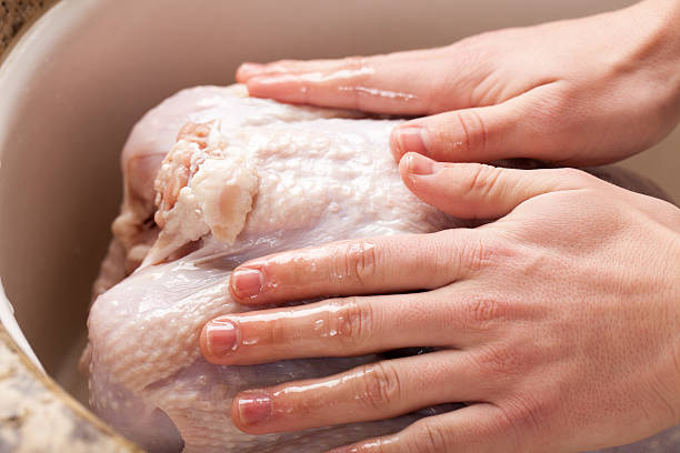 istock Hands rubbing olive oil over raw turkey 505491746