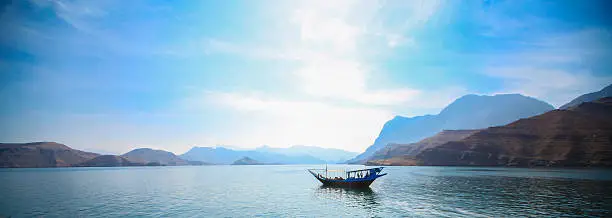 A traditional dhow can be seen moving across the Persian Gulf in the Musandam, Oman. 