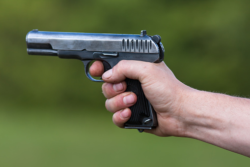 the TT pistol in hand on blurred background