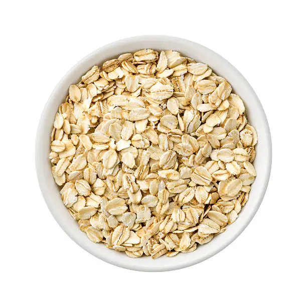 Overhead View of Organic Rolled Oats in a ceramic bowl. Rich in fiber and nutrition. The image is a cut out, isolated on a white background, with a clipping path.