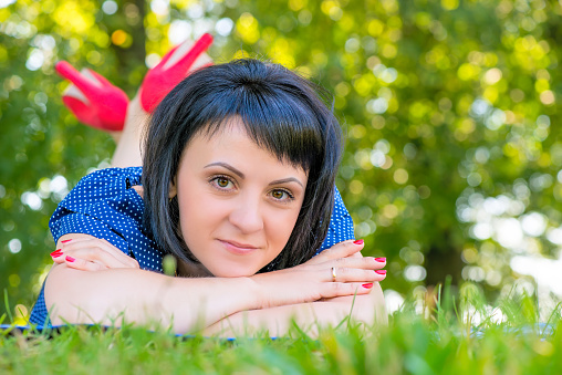 portrait of a girl with black hair lying on the lawn