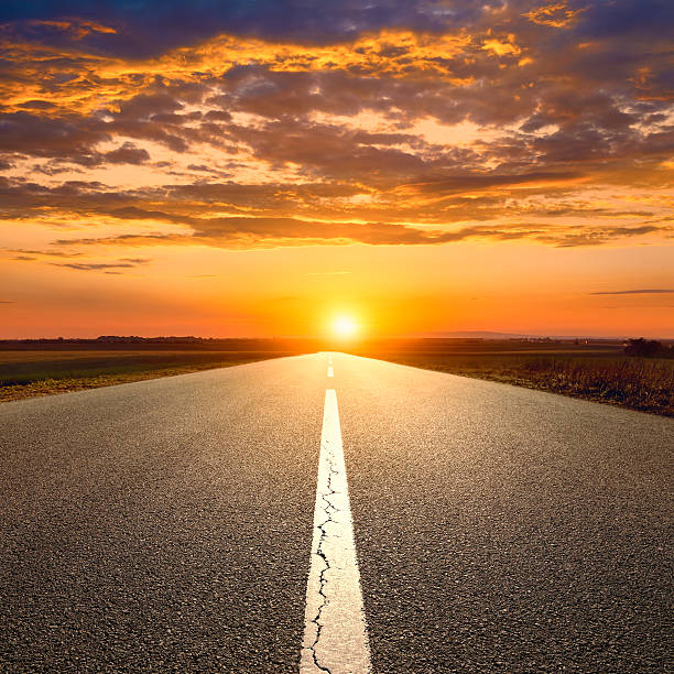 istock Driving on an empty road towards the sunset 505502099