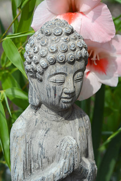 istock Buddha with flowers and bamboo 505502315