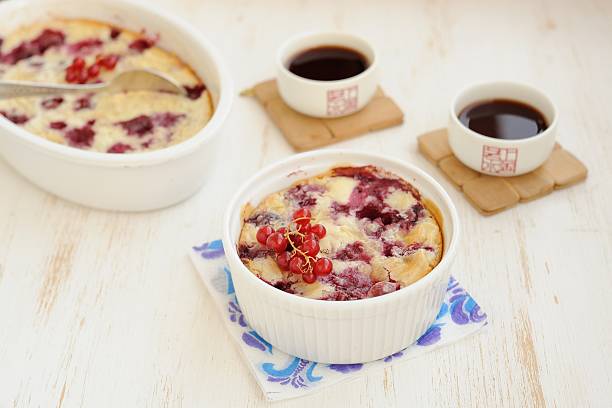 Clafoutis with cherry and red currants Clafoutis with cherry and red currants on the white background with blue napkin and black shu puerh clafoutis stock pictures, royalty-free photos & images