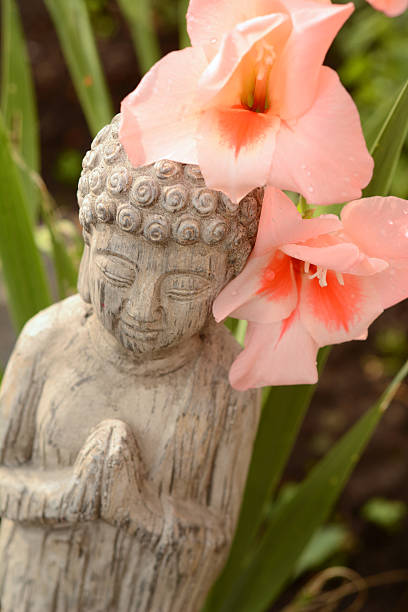 istock Buddha with flowers and bamboo 505506285