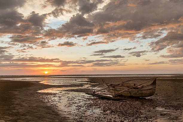 istock Old wooden sailor boat stranded on a sunset beach 505513806