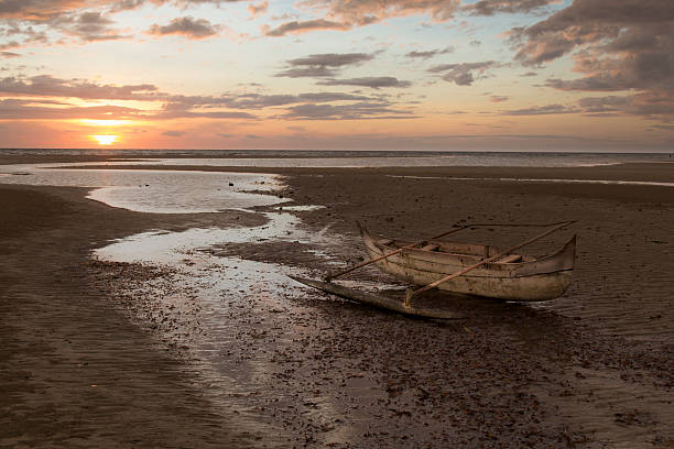 istock Old wooden sailor boat stranded on a sunset beach 505513938