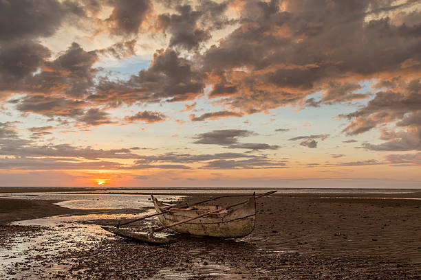 istock Old wooden sailor boat stranded on a sunset beach 505514202
