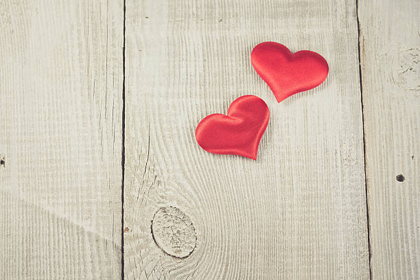 istock Two hearts hanging on wooden background 505514590