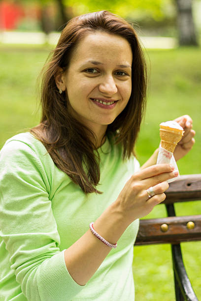 istock smiling woman is eating an ice cream 505519507