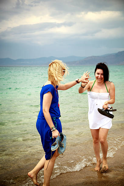 Two beautiful young women on the beach. Brunette and blond