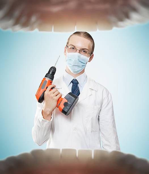 Dentist from hell Dreadful dentist with electric drill symbolizing fear of pain. dental drill stock pictures, royalty-free photos & images