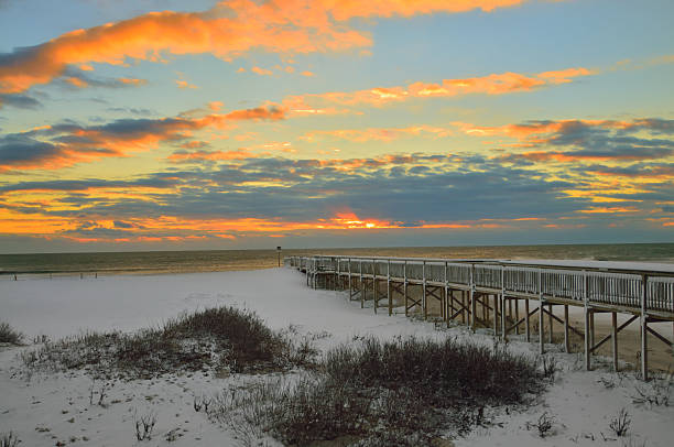 Assateague Beach Walkway In Snow The walkway over the dunes to the beach at the Assateague Island National Seashore at sunrise with some alto cumulus clouds lit up by the rising sun assateague island national seashore photos stock pictures, royalty-free photos & images