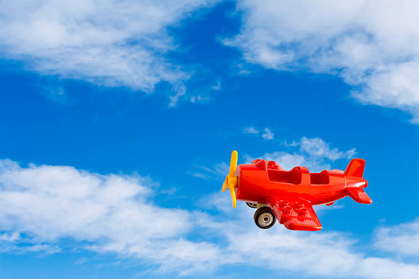 istock Abstract: red toy airplane on a background of blue sky 505520360