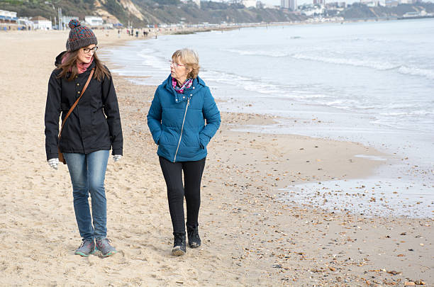 istock Two women one older and one younger walking on beach 505523682