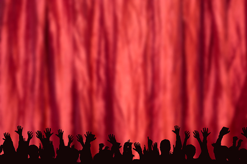 NOTE TO INSPECTOR:  The source image is attached for the crowd silhouette. Many people's hands raised at a party, celebration, or entertainment event. Red stage curtains behind the crowd of unrecognizable people, which are in black silhouette.  The illustration of people lines the bottom of the image with the top blank for your copy.  Various concepts.